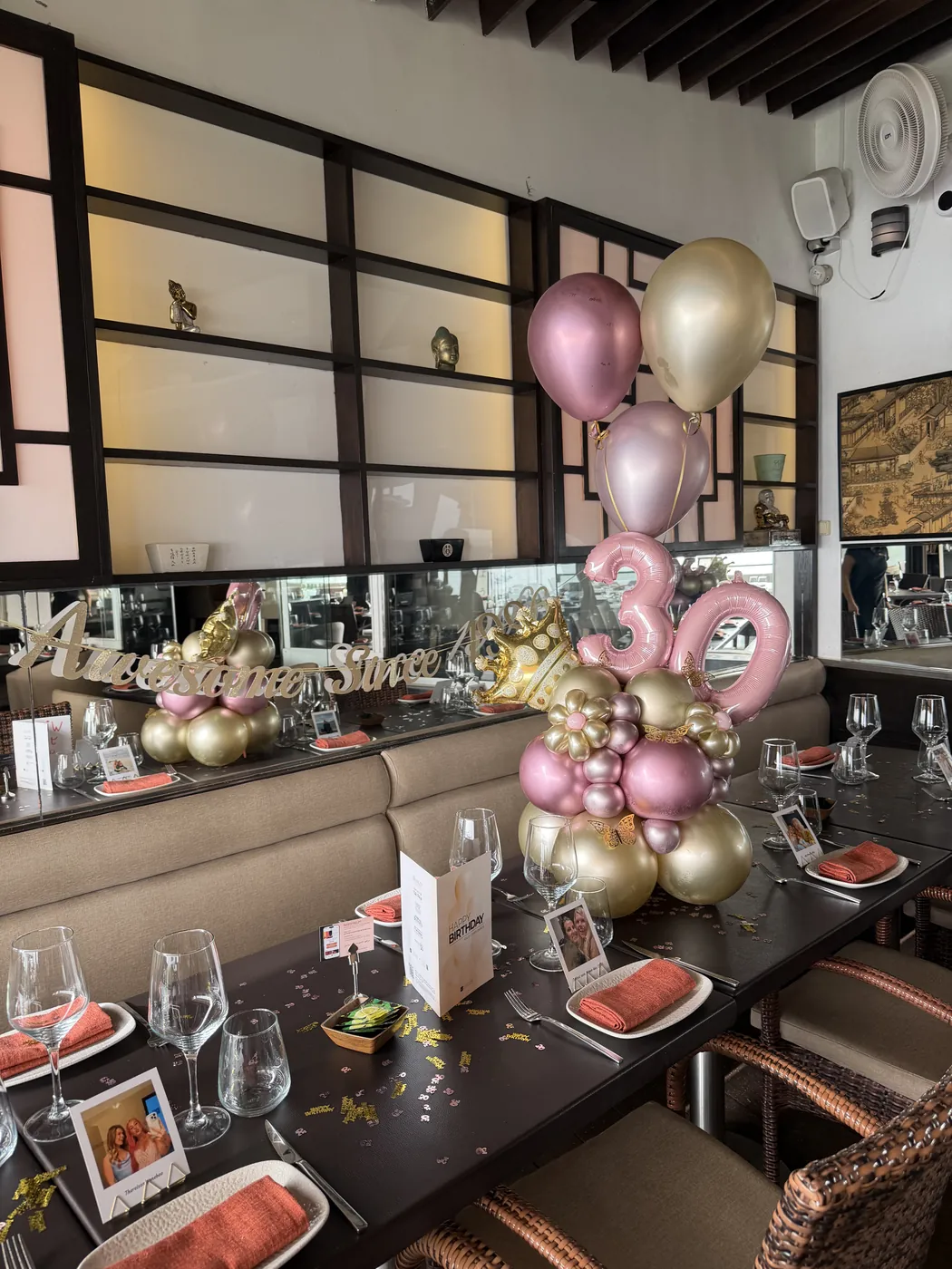 Restaurant table styled with a pink and gold balloon centrepiece